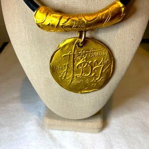 Donna Karen 1990s rich gold pendant on a black necklace chain. Exquisite!